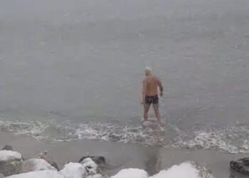 Baie în mare, în plină furtună